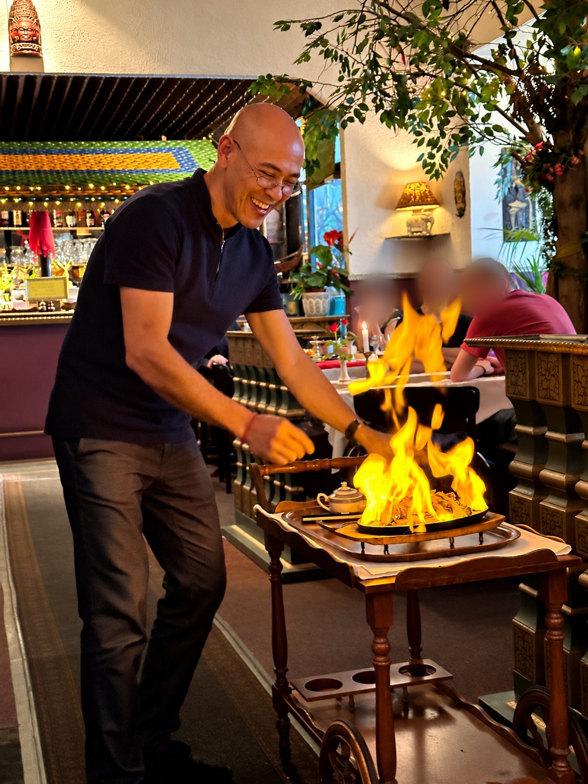 Ein Gericht wird am Tisch flambiert, die Flammen schlagen hoch