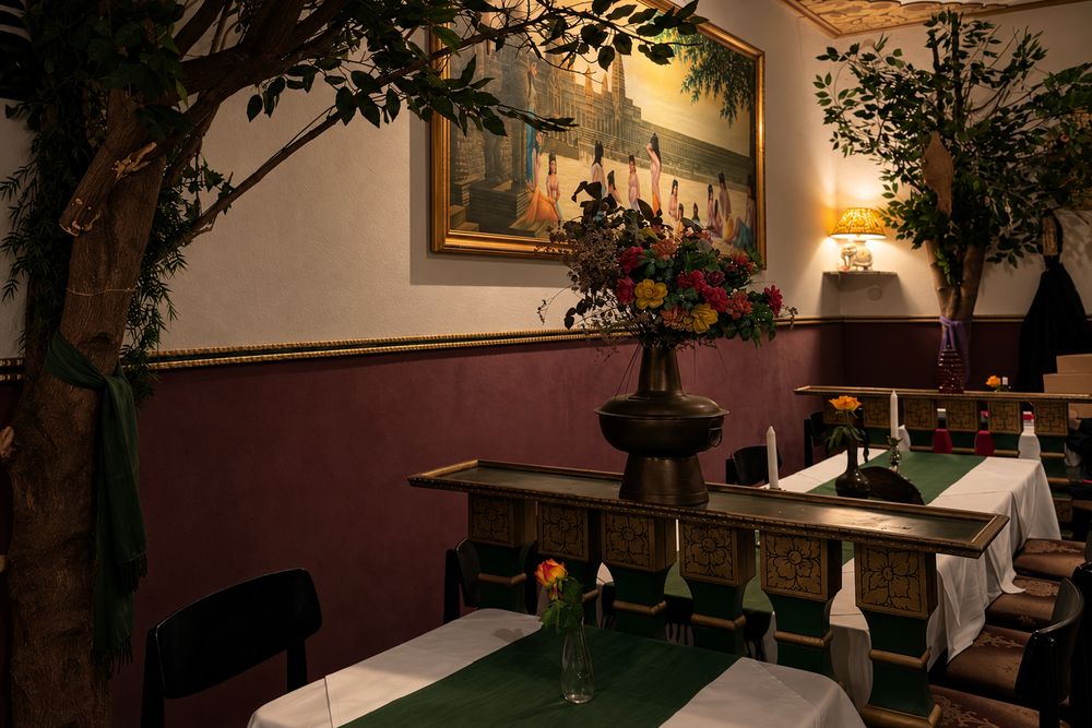 Sitznische mit grünen Tischläufern und Blumen